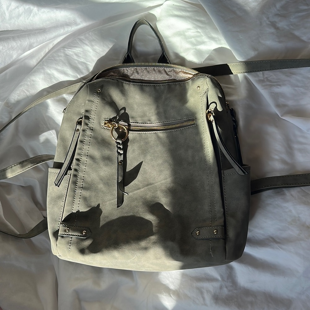Super cute grey faux leather backpack with adjustable straps , lots of pockets!